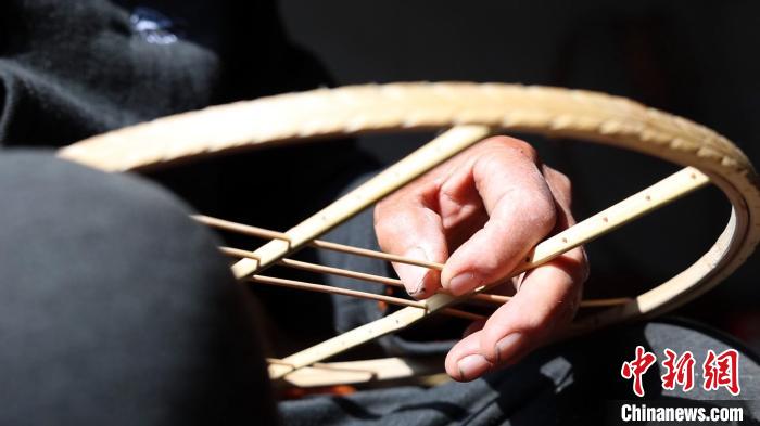 鳥籠藝人侯學(xué)文正在用竹條制作鳥籠。　巨野融媒中心供圖